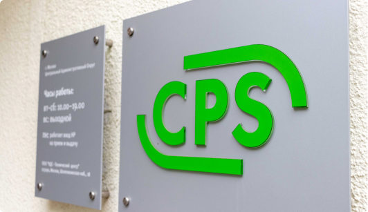 Фото табличек с логотипом CPS на стене здания и временем работы организации